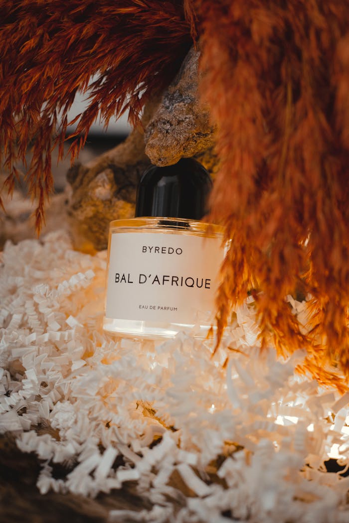 Elegant Byredo Bal d'Afrique perfume enveloped in a luxurious feather setting.